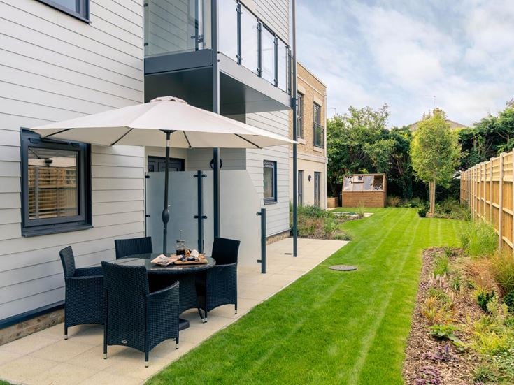 a backyard with a grill and a table and chairs