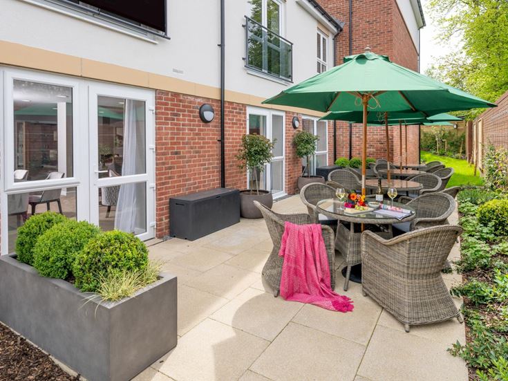 a patio with a table and chairs and umbrellas