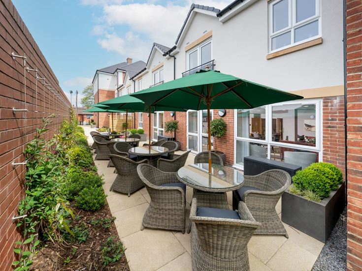 a patio with a table and chairs and umbrellas