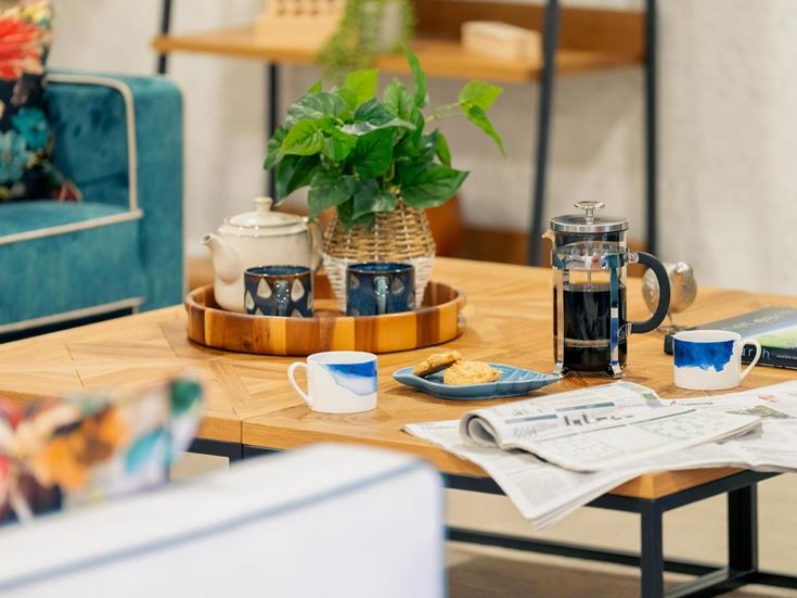 a table with a plant and cups on it