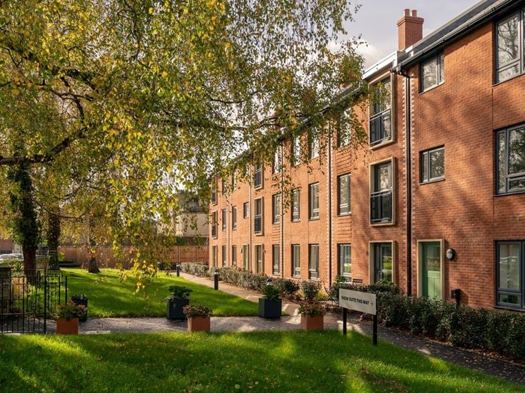 a brick building with trees in front