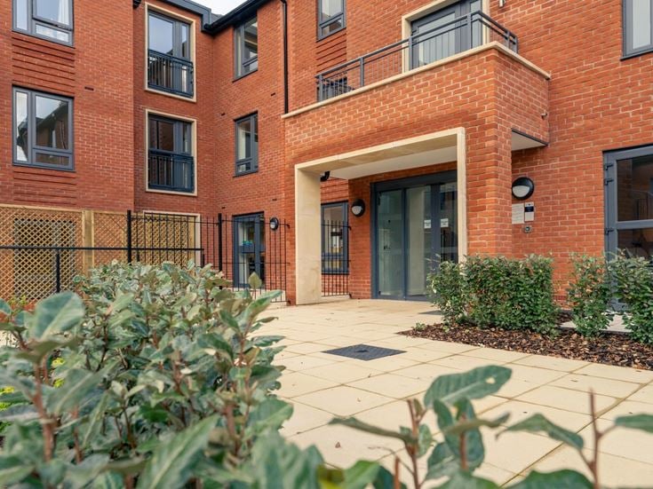 a brick building with a green lawn