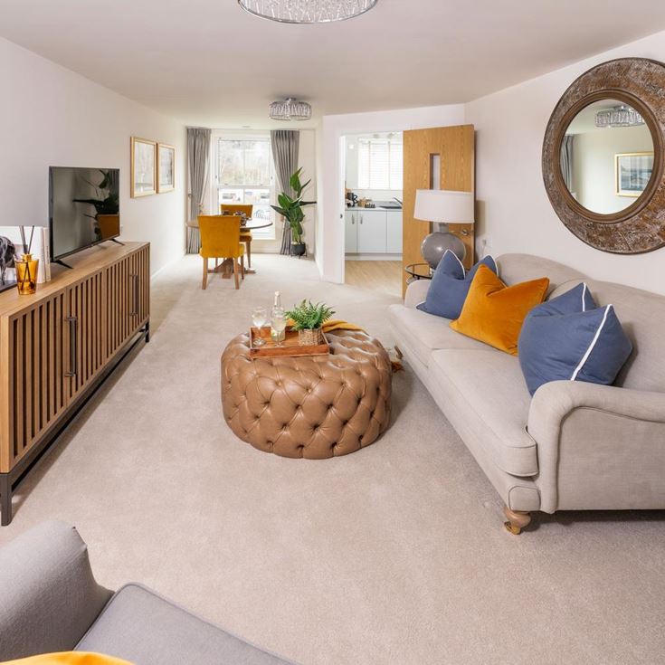 a living room with a couch and a round mirror