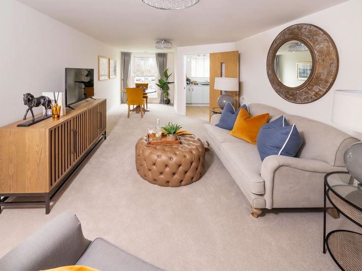 a living room with a couch and a round mirror
