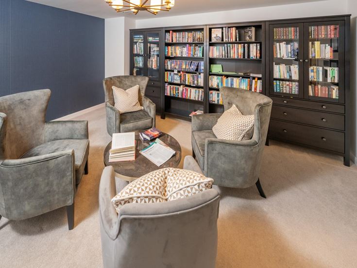 a room with a bookcase and chairs