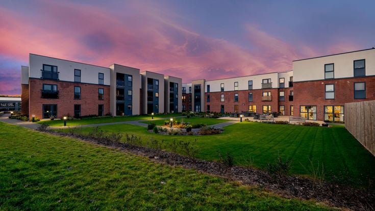 a row of buildings with a grassy field in front of them