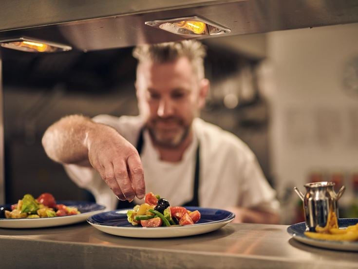 a person sitting at a table with food on it