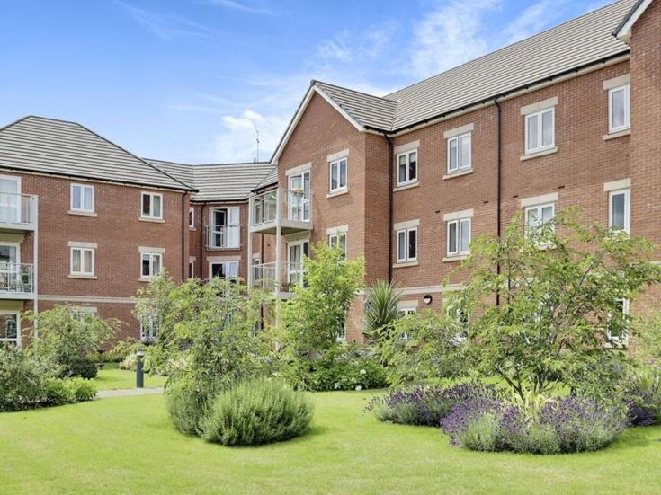 a large brick building with a garden