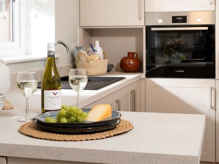 a kitchen with a plate of food and wine glasses