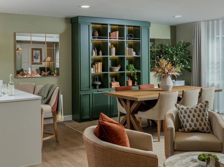 a room with a table chairs and a mirror