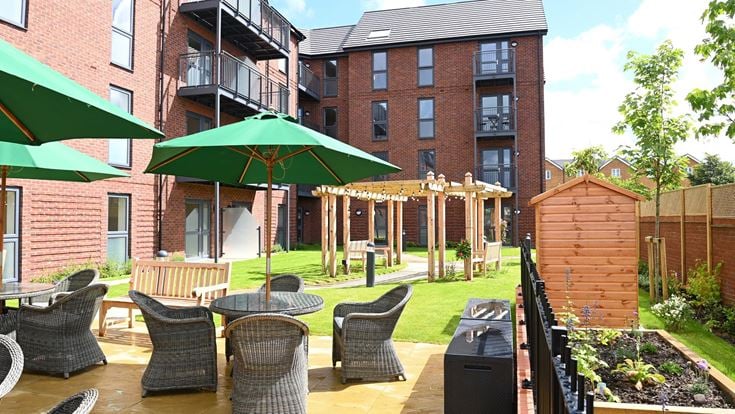 a patio with a table and chairs and a green umbrella
