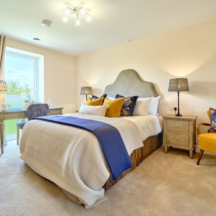 a bedroom with a bed and chairs