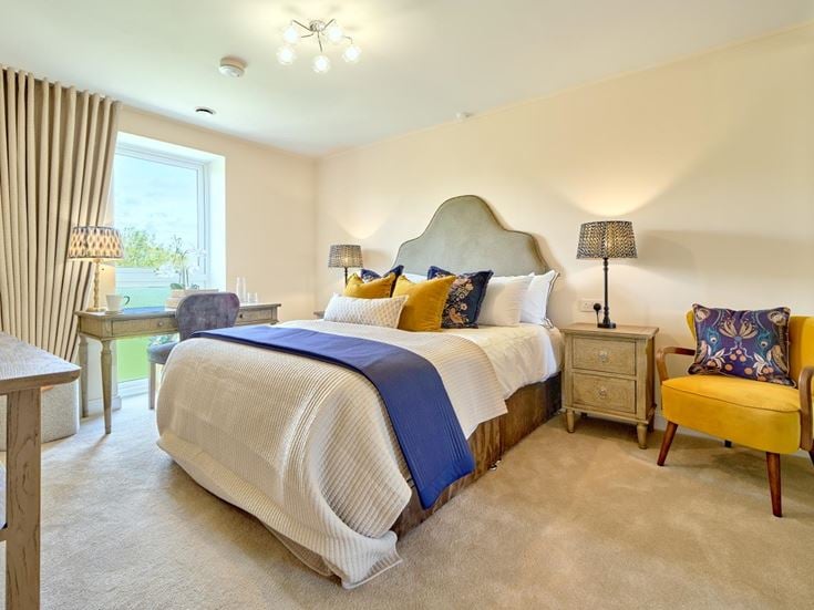 a bedroom with a bed and chairs