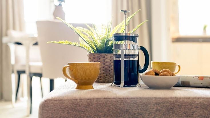 a table with a vase of flowers and a bowl of nuts