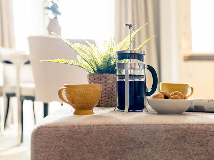 a table with a vase of flowers and a bowl of nuts