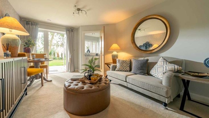 a living room with a white couch and a large mirror