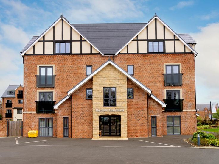 a brick building with a parking lot