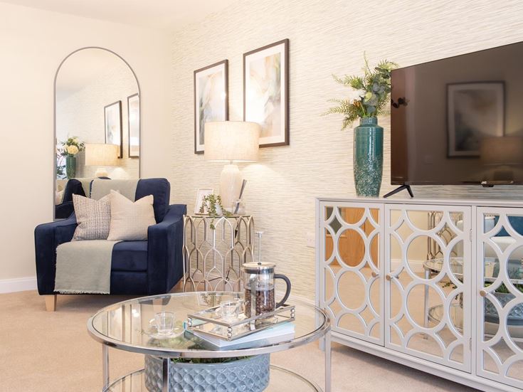 a living room with a glass coffee table and a chair