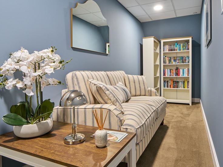 a living room with a couch and a table with a plant on it