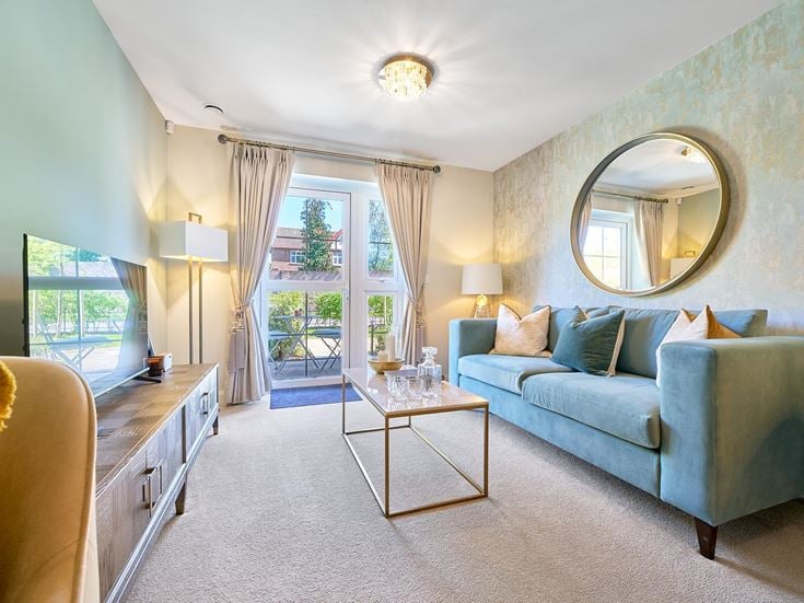 a living room with a blue couch and a round mirror