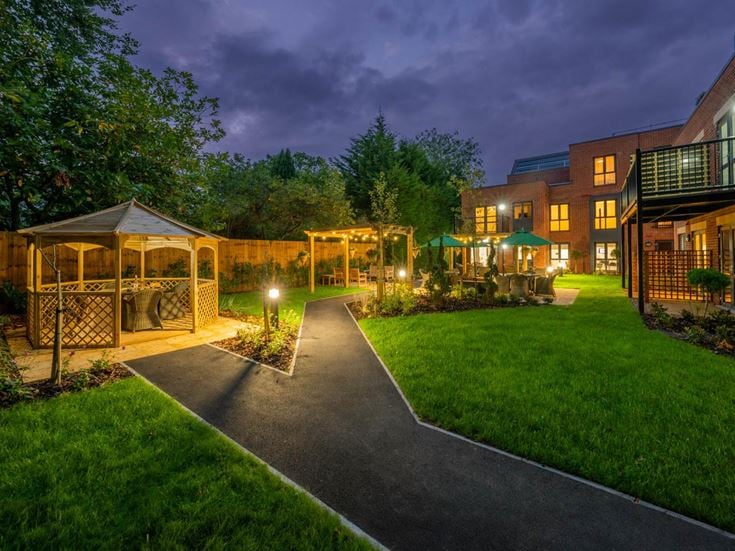 a backyard with a fence and a path leading to a house