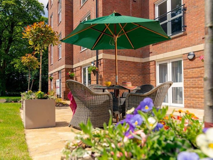 a patio with a table and chairs and a green umbrella