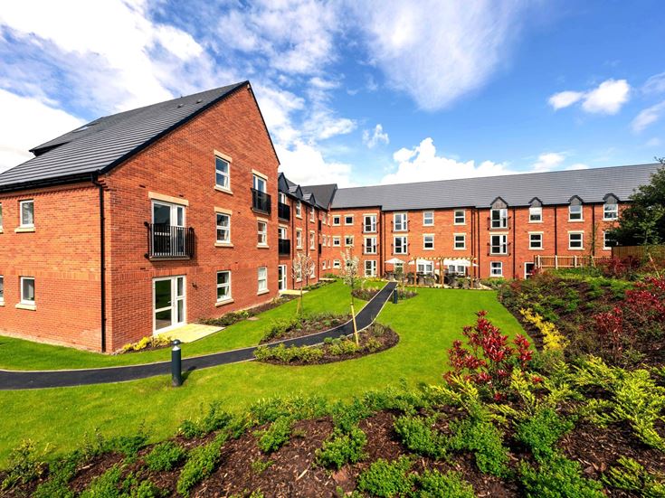 a brick building with a garden in front of it