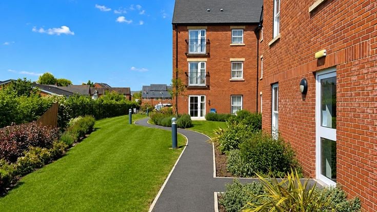 a long brick building with a path