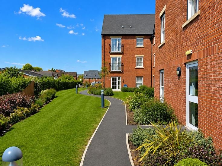 a long brick building with a path