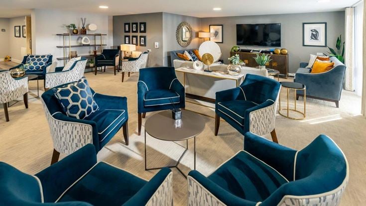 a living room with blue chairs and a table