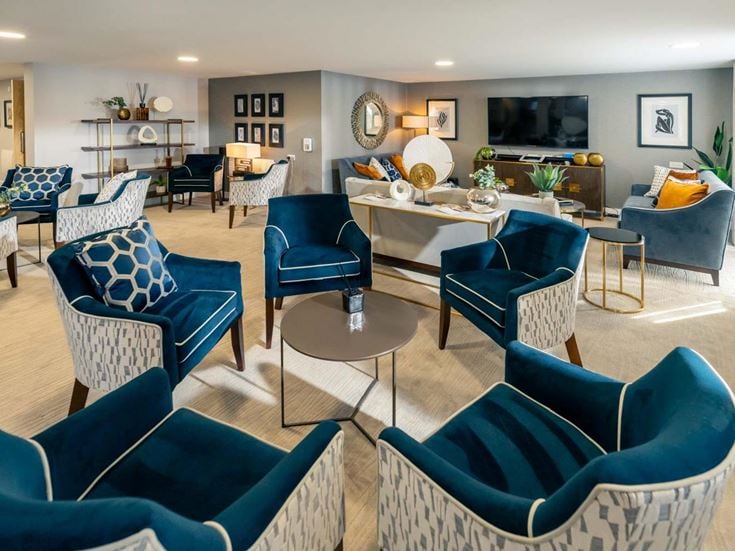 a living room with blue chairs and a table