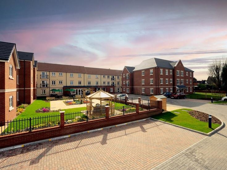 a brick walkway leading to a row of buildings