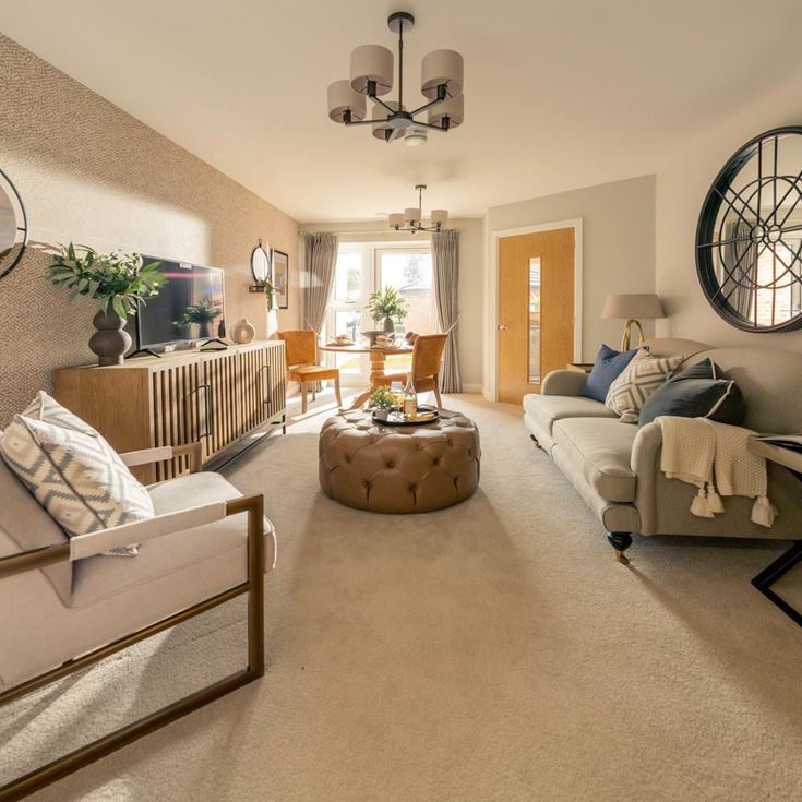 a living room with a white couch and a round mirror