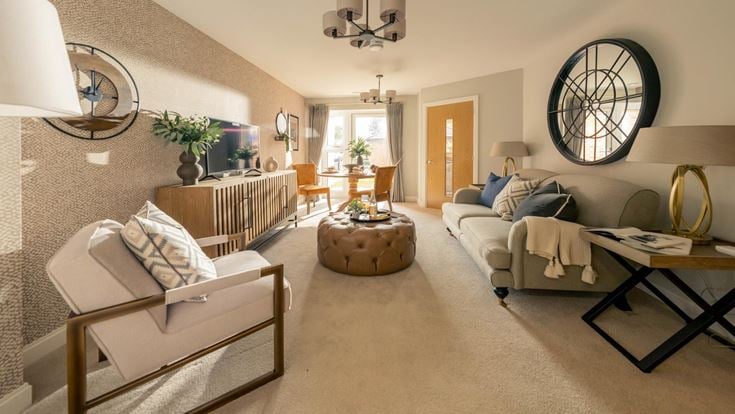 a living room with a white couch and a round mirror