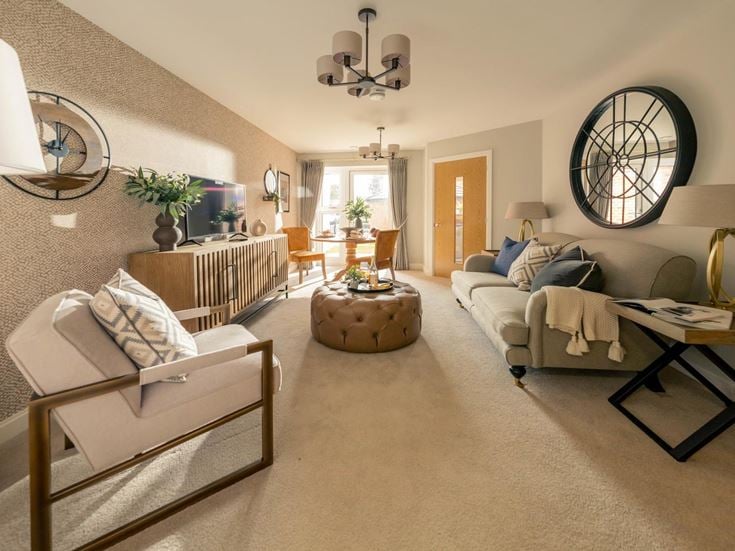 a living room with a white couch and a round mirror