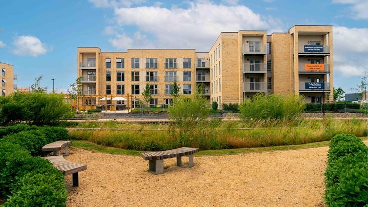a park with benches and buildings in the background