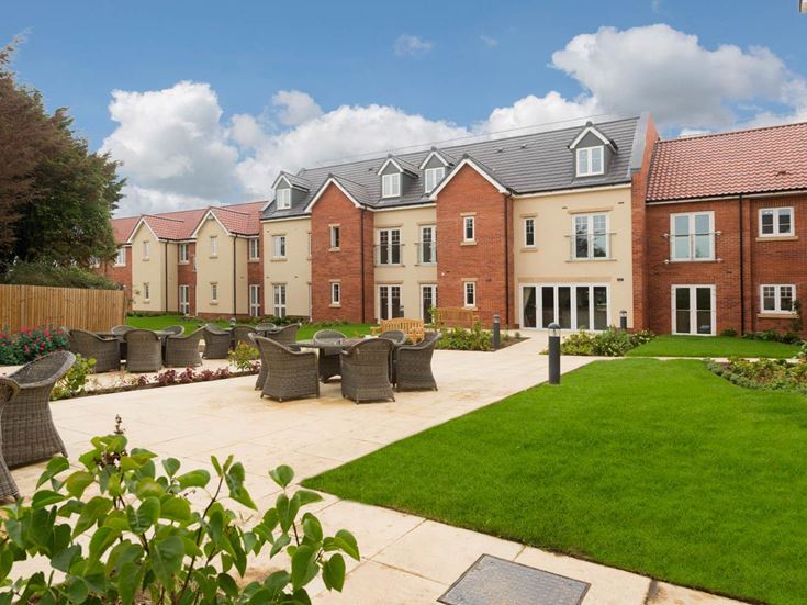 a brick building with a green lawn