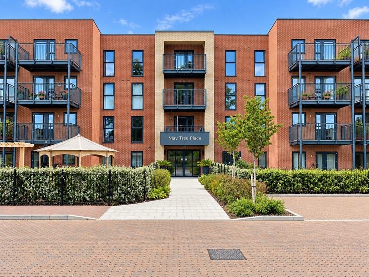 a building with a walkway and trees