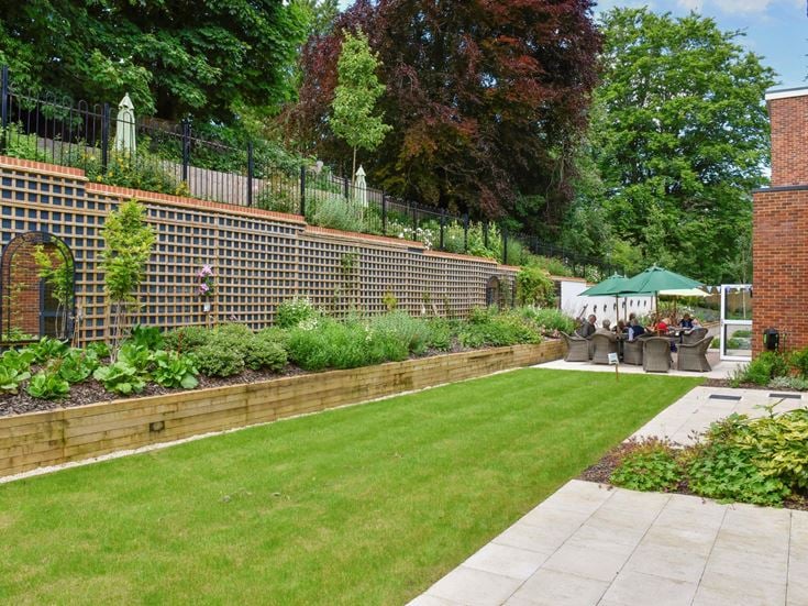 a brick wall with a brick fence and a lawn with a stone wall
