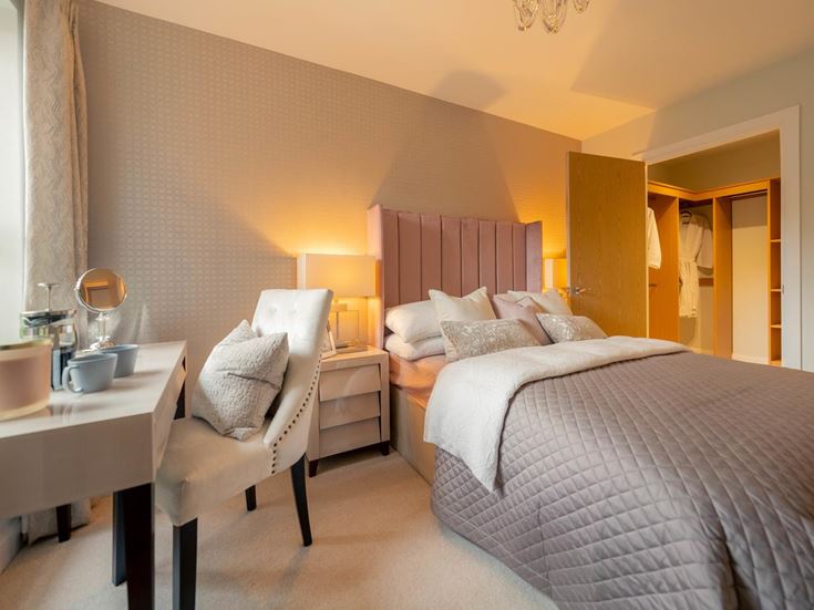 a hotel room with a bed desk and chair