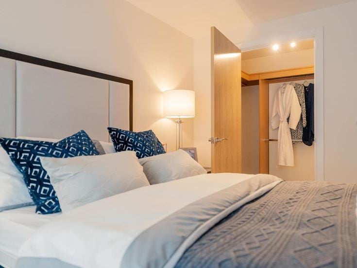 a hotel room with a bed and a lamp