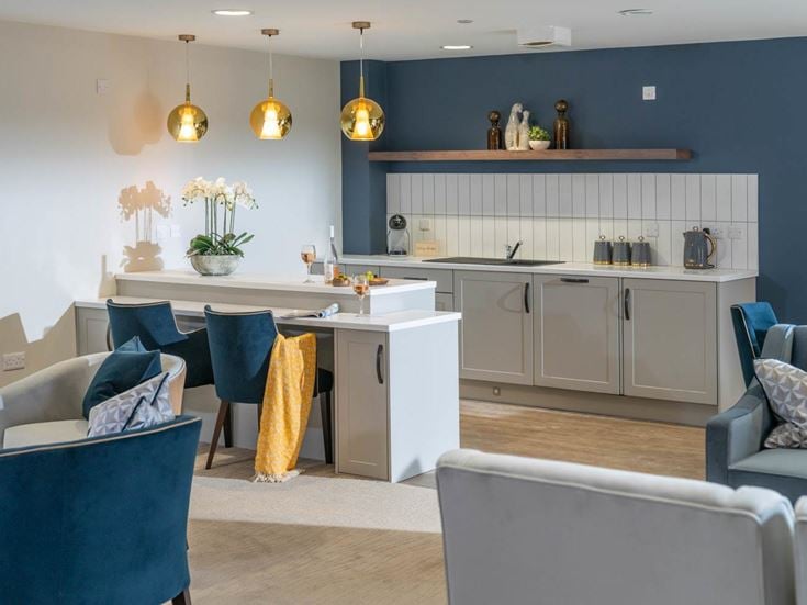 a kitchen with a bar and chairs