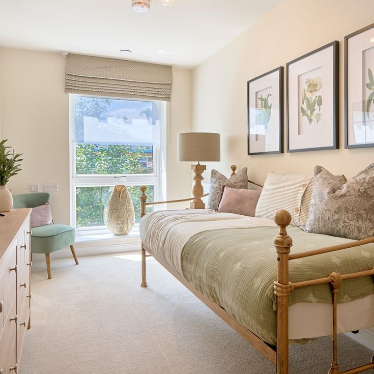 a bedroom with a bed desk and a window