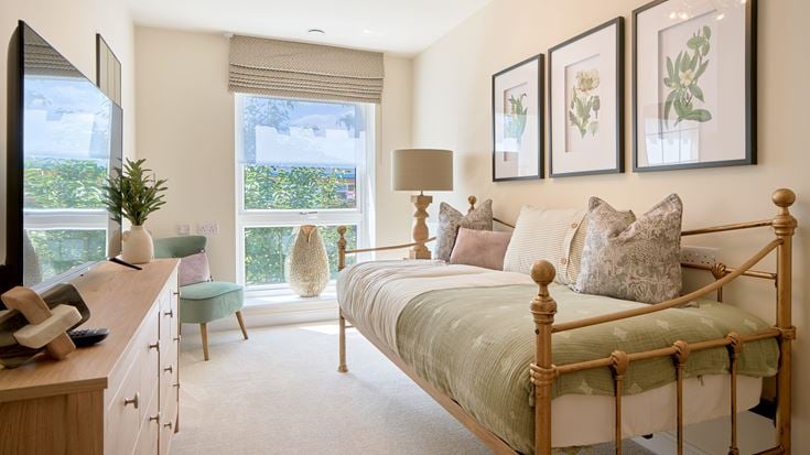 a bedroom with a bed desk and a window