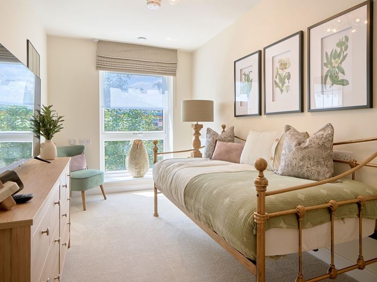 a bedroom with a bed desk and a window