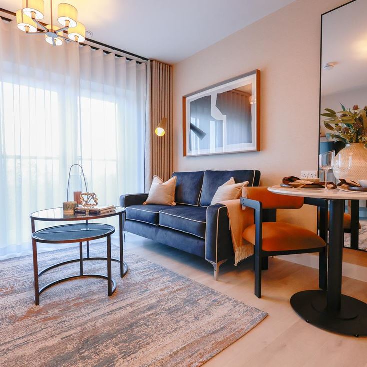 a living room with a blue couch and a table