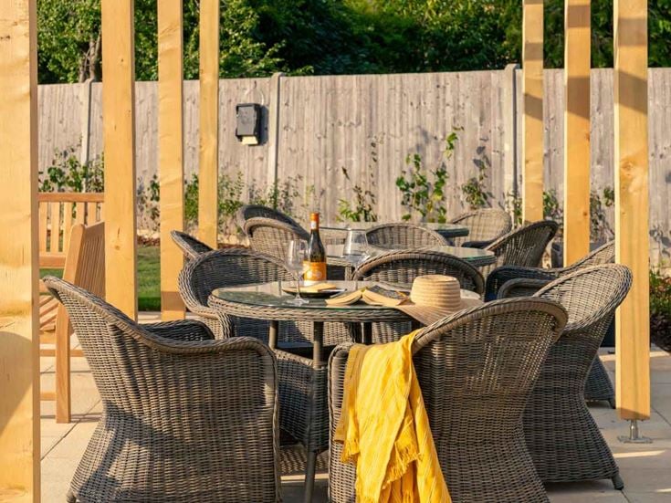 a table set with chairs and a wood fence