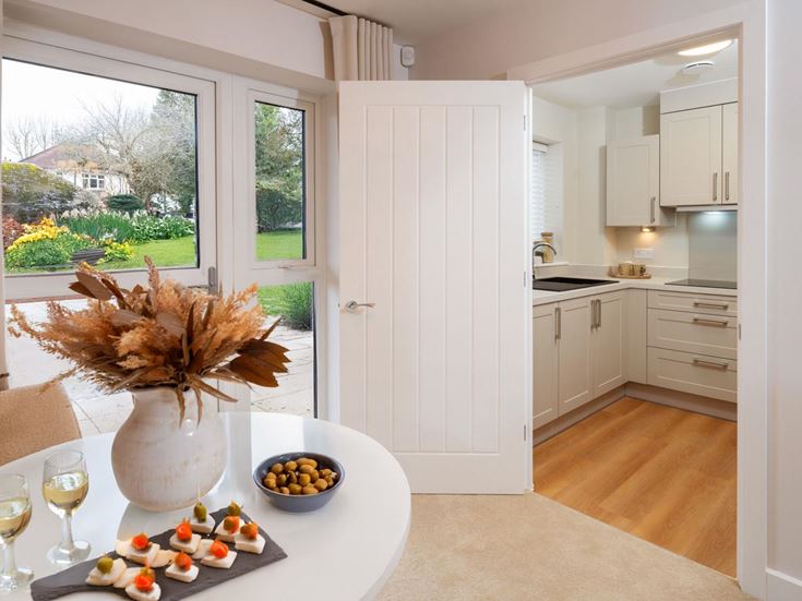 a kitchen with a table and a vase with flowers on it