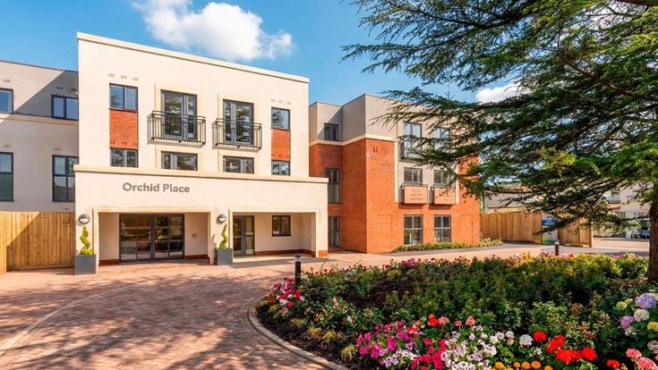 a building with a flower bed in front of it