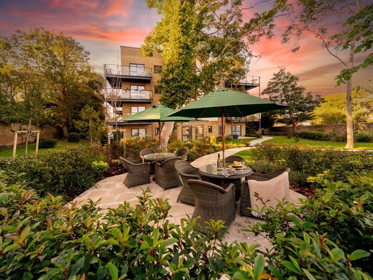 a courtyard with a table and chairs and umbrellas